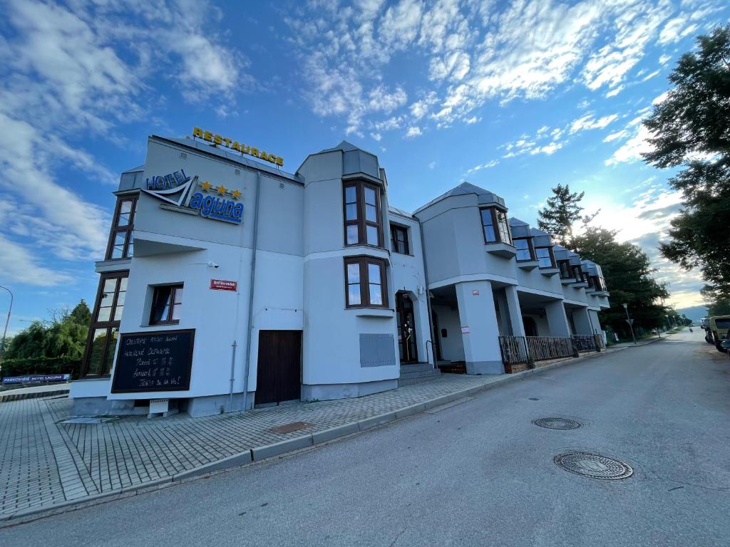 un edificio blanco al lado de una calle en Hotel Laguna & restaurant en České Budějovice