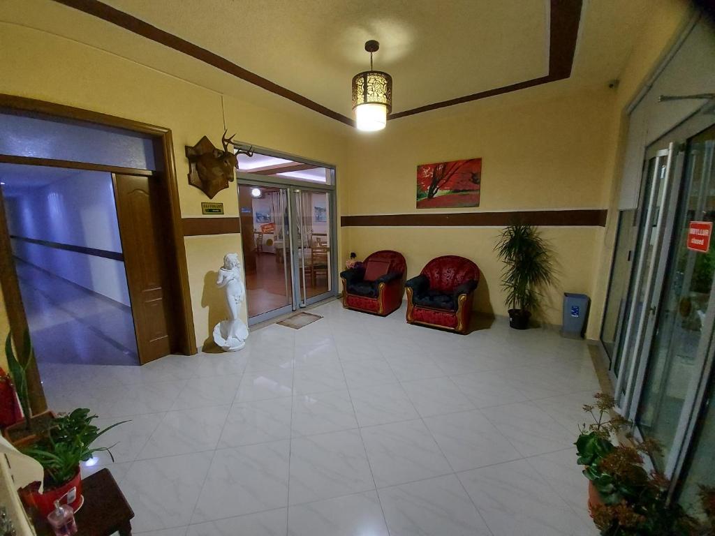 un vestíbulo vacío con sillas y una gran puerta de cristal en HOTEL KALEMI en Çorovodë