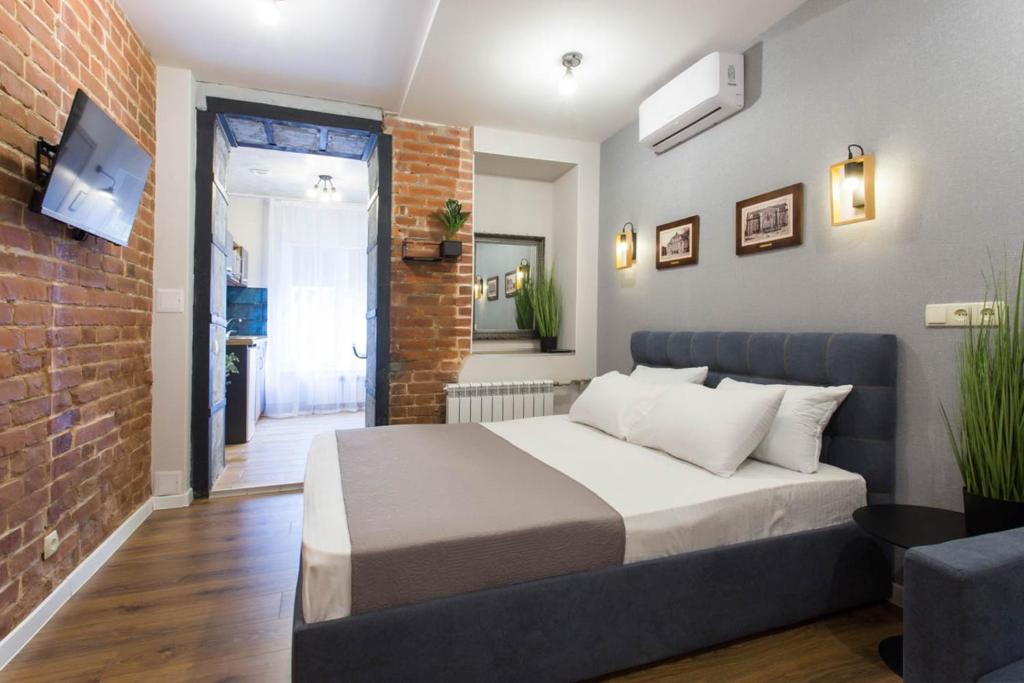 - une chambre avec un lit et un mur en briques dans l'établissement Cozy apartment in the Center - Podilskyi lane 7, à Kharkov