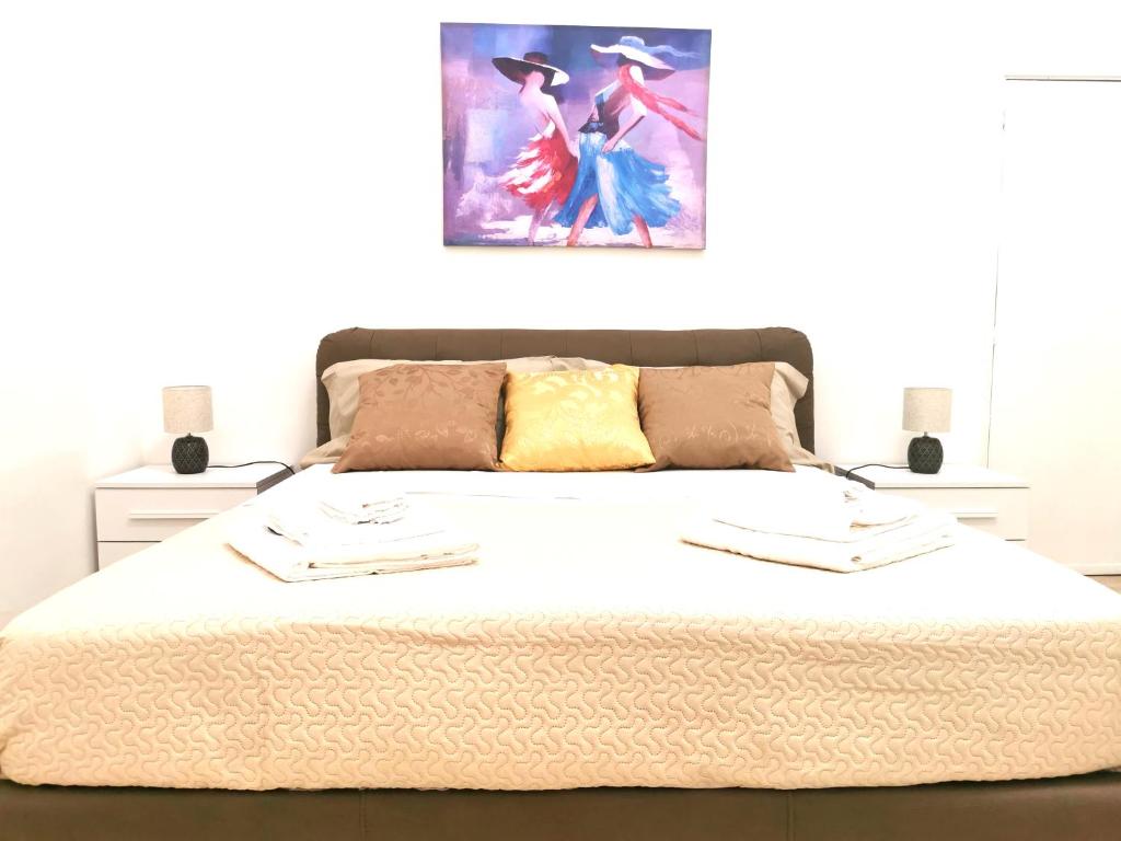 una camera da letto con un letto e un dipinto sul muro di Don Carlo Casa Vacenze a Campi Salentina