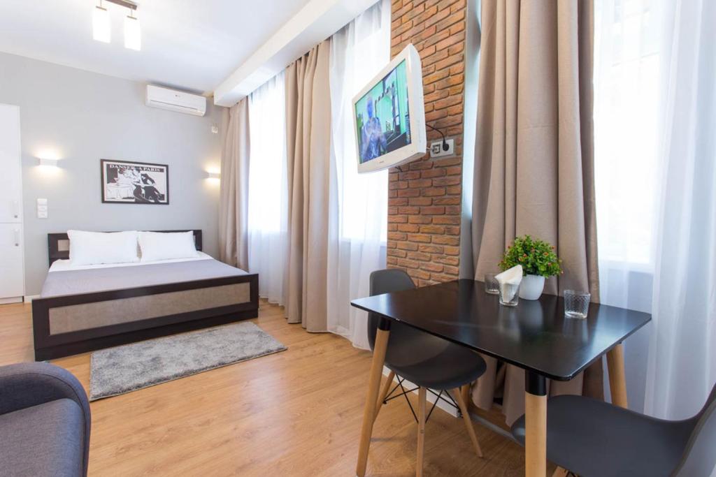 a bedroom with a bed and a table in a room at Modern studio beside metro Pushkinska, Universytet - Chernyshevska str. 95-7 in Kharkiv