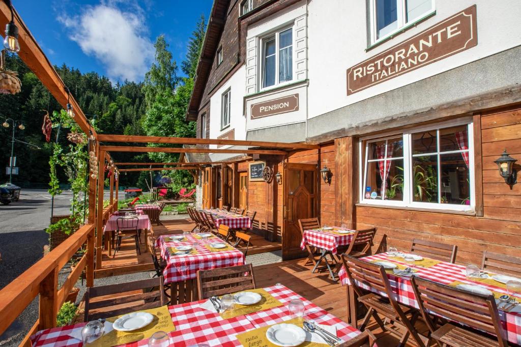 an outdoor patio of a restaurant with tables and chairs at Penzion Sofinata & Trattoria Lucio Špindlerův Mlýn in Špindlerův Mlýn