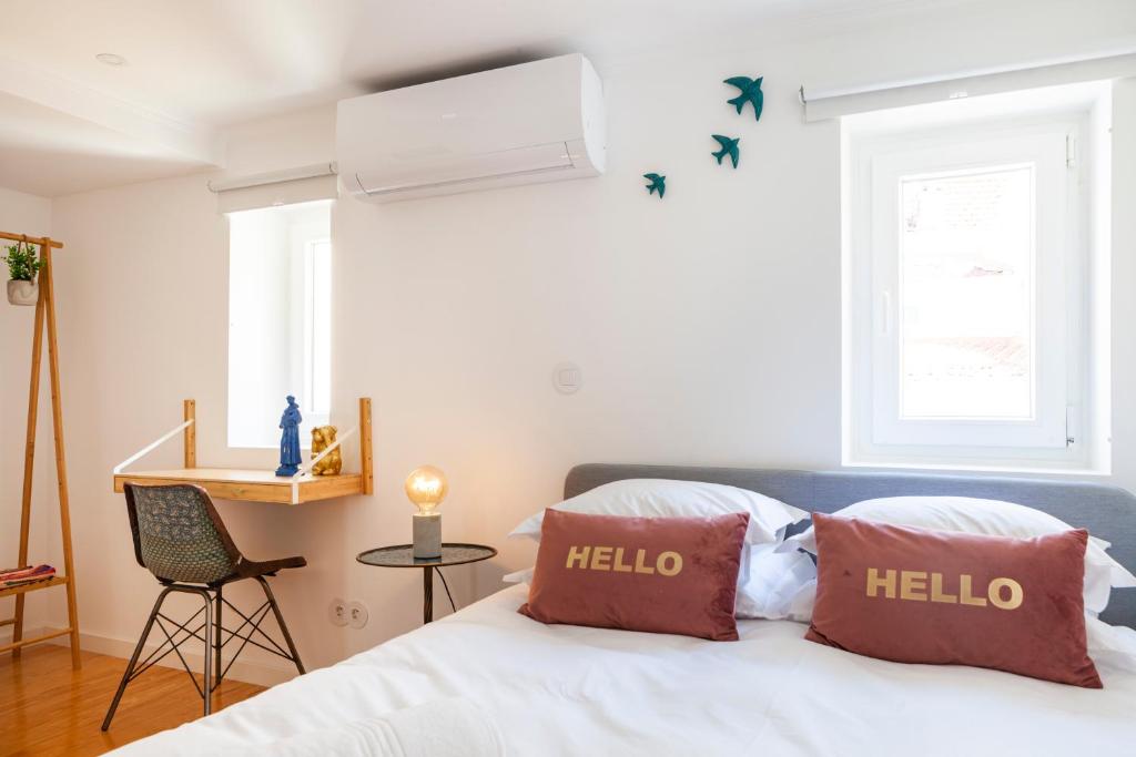 um quarto com uma cama com duas almofadas vermelhas em Lisbon Chillout Apartments em Lisboa