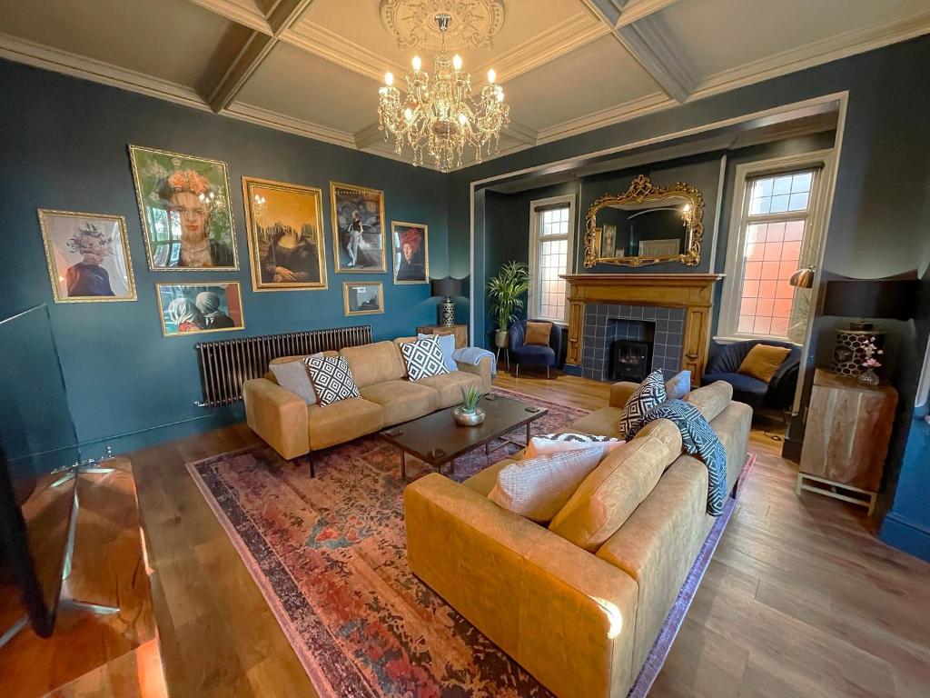 a living room with two couches and a fireplace at Selworthy - Luxury 3 Bedroom Apartment in Yeovil