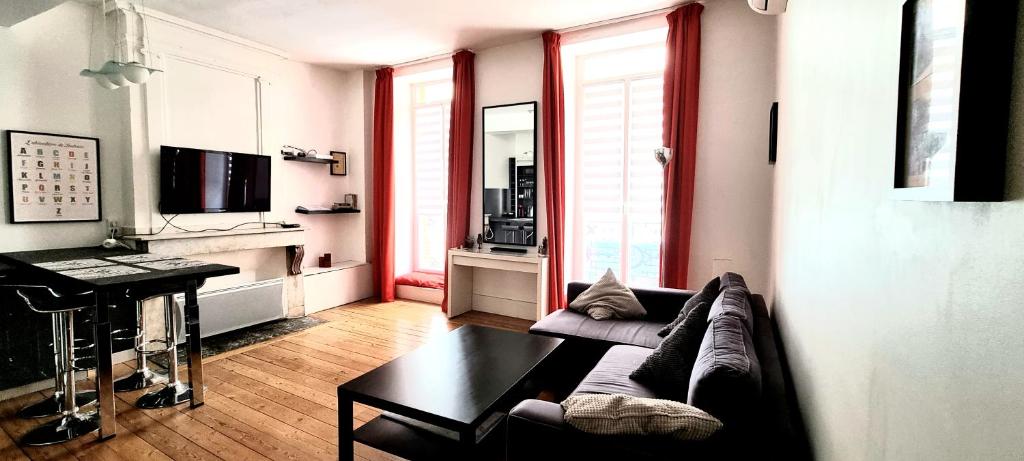 a living room with a couch and a table at T2 COSY - CAPITOLE - CALME - Wi-Fi - NETFLIX in Toulouse