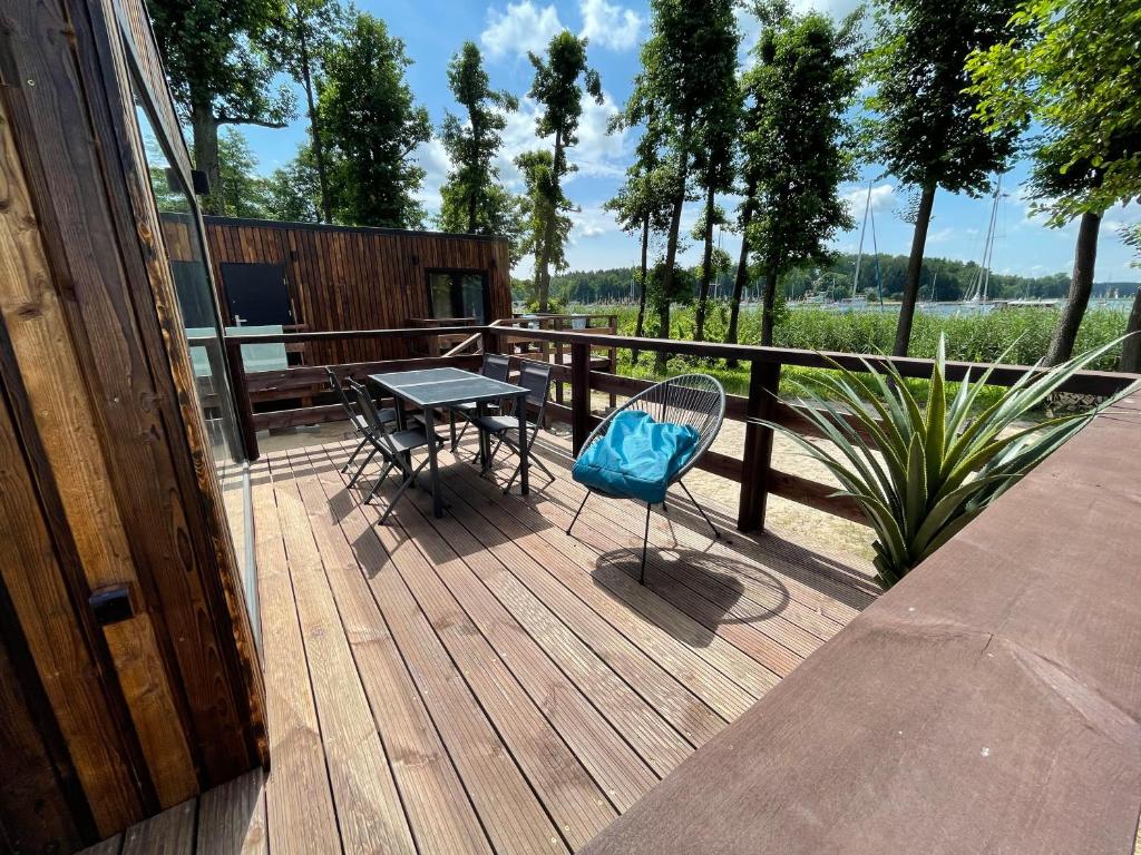 a patio with a table and a chair on a deck at XOXO Lake House in Giżycko