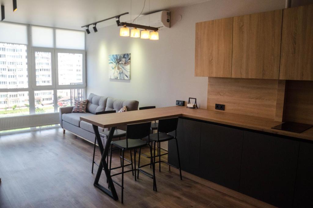 uma cozinha com uma mesa e um sofá em Kokos Avenue Loft Apartments em Yuzhne