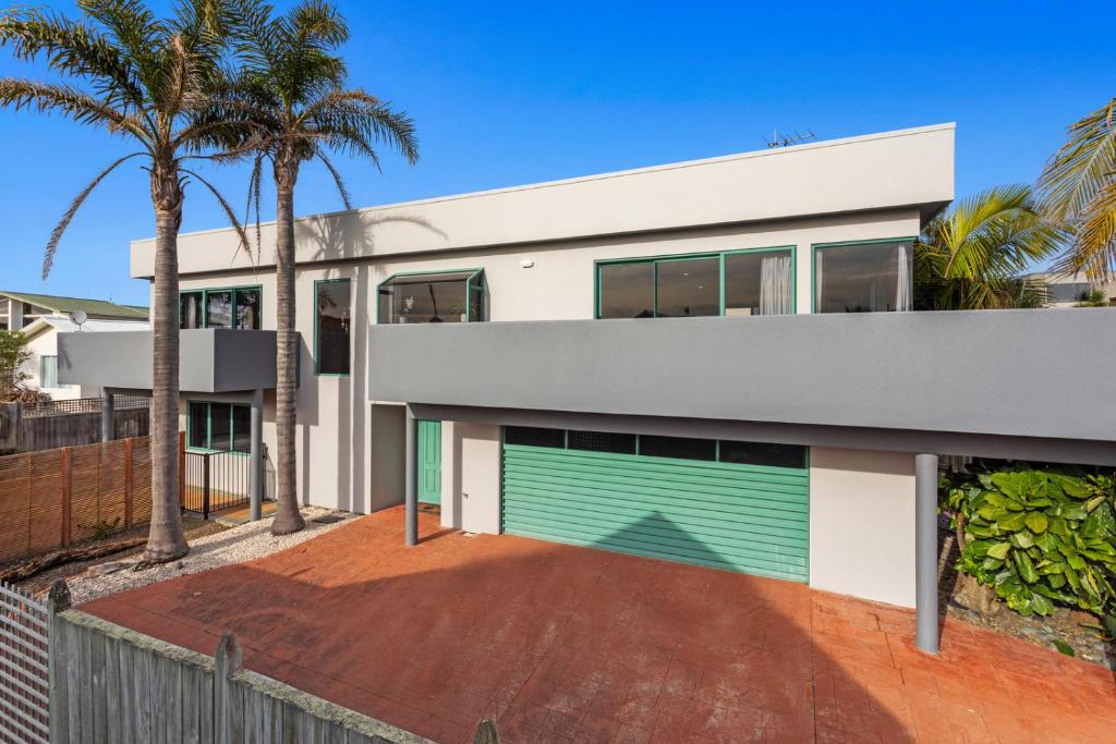 an image of a house with a green garage at Ohope Palms - Ohope Holiday Home in Ohope Beach