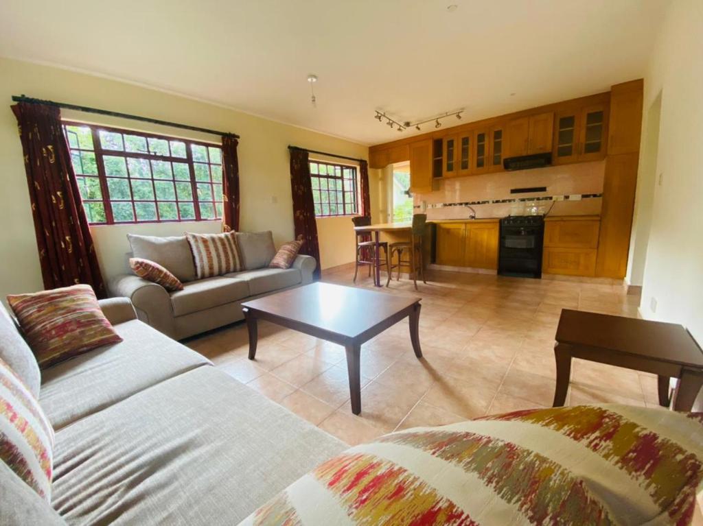 a living room with a couch and a table at Twiga Hill Gardens in Nairobi