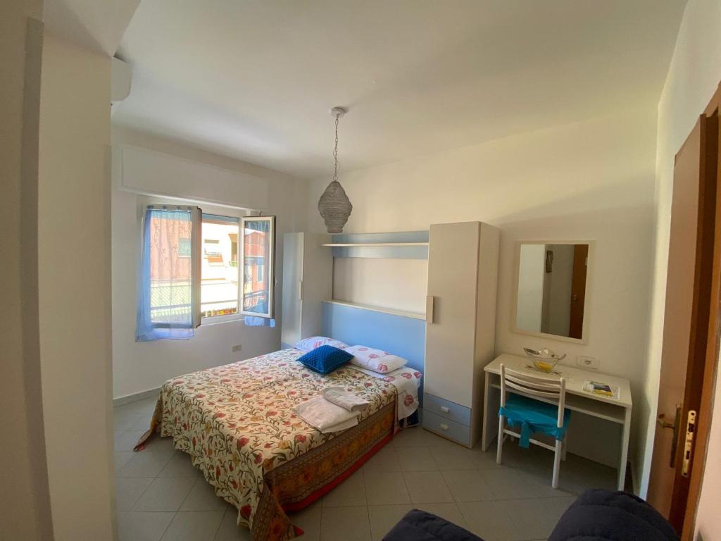 Schlafzimmer mit einem Bett, einem Schreibtisch und einem Spiegel in der Unterkunft Raggi di Sole in Monterosso al Mare