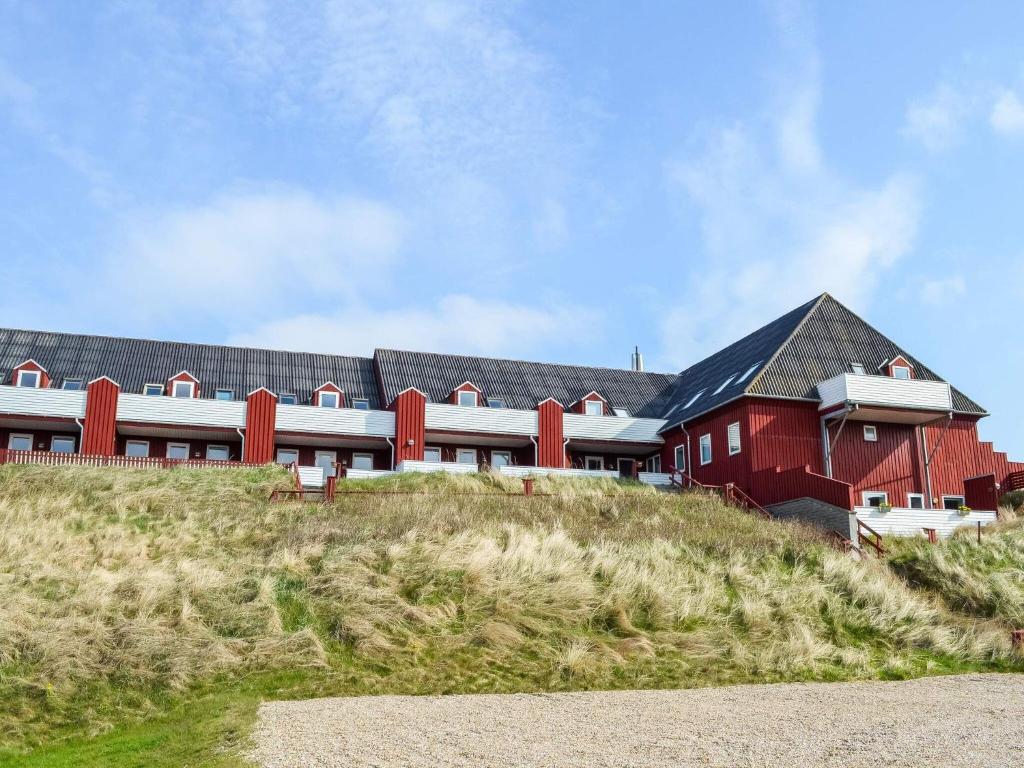 un gran edificio rojo en la cima de una colina en Holiday home Henne XXXVIII, en Henne Strand