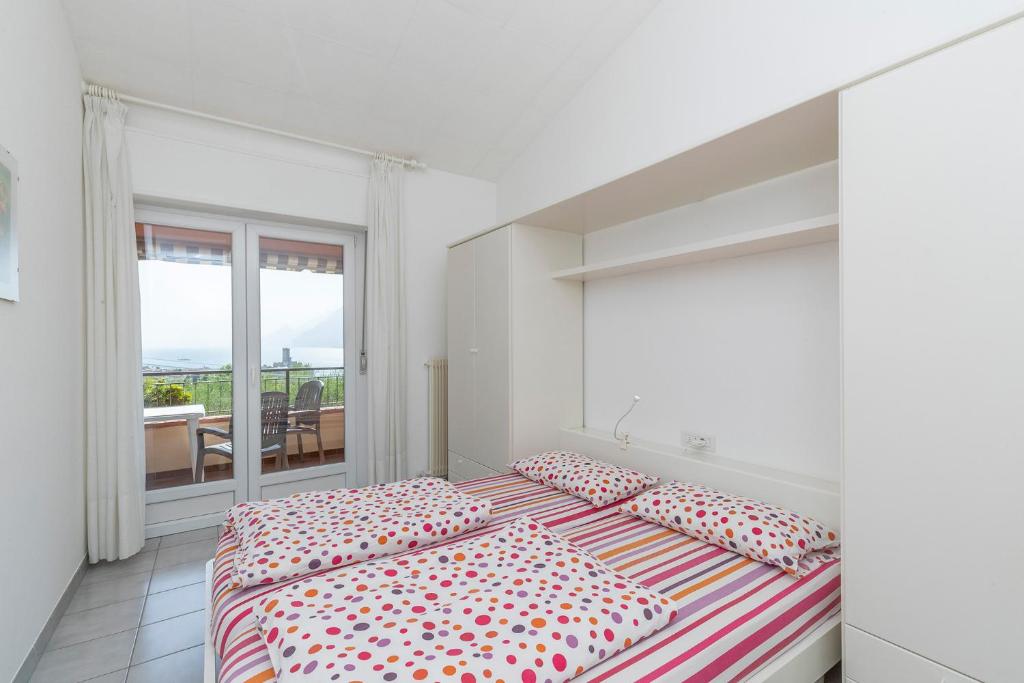 Biała sypialnia z 2 łóżkami i balkonem w obiekcie Apartament Kormorano w mieście Malcesine