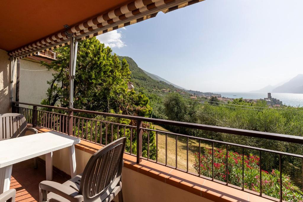 balkon ze stołem i krzesłami oraz widokiem na ocean w obiekcie Apartament Kormorano w mieście Malcesine