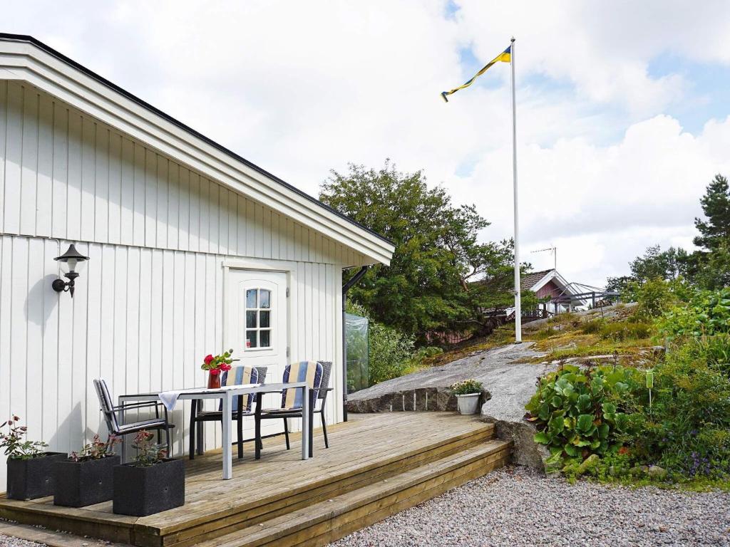 drewniany taras ze stołem i krzesłami na boku budynku w obiekcie 2 person holiday home in STR MSTAD w mieście Strömstad
