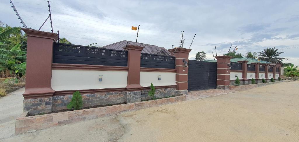 a building with a fence on the side of it at Mama Jane's Villa in Kasanwere