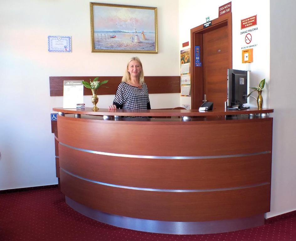 kobieta siedząca w recepcji poczekalni w obiekcie Hotel Aleksander w Ustce