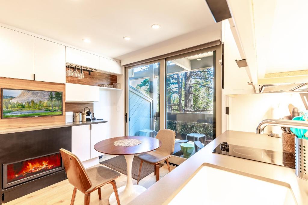 a kitchen with a table and chairs and a fireplace at Modern Hotel-Style Studio - Timber Creek Lodge #210 Hotel Room in Truckee