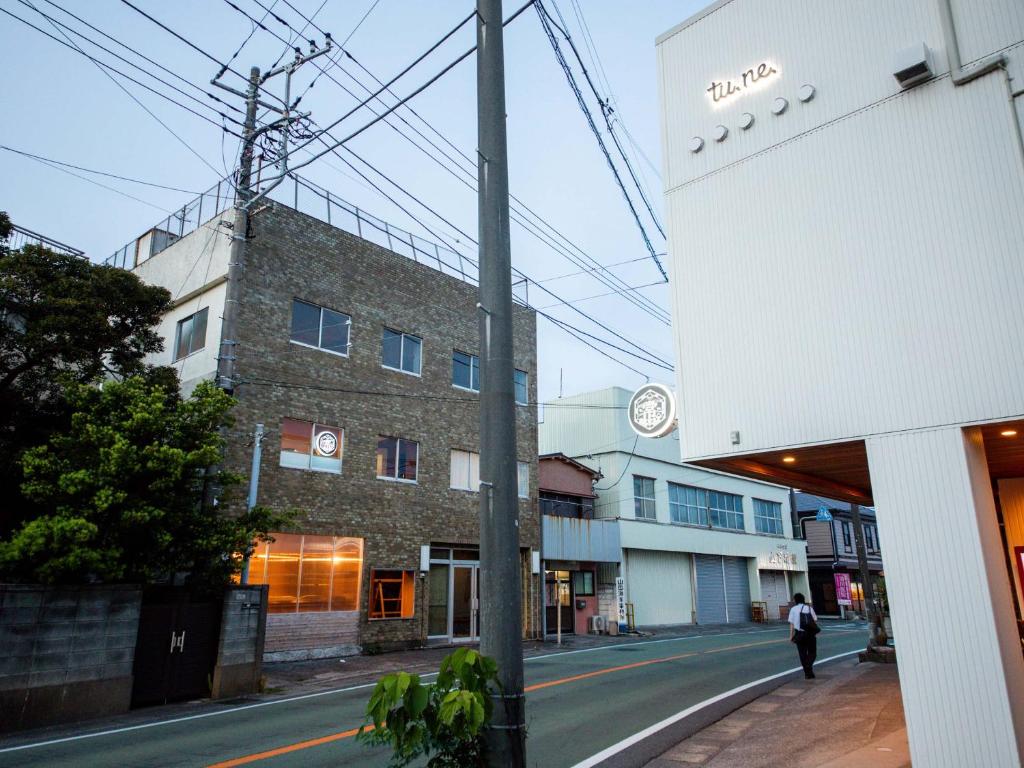 una persona caminando por una calle al lado de un edificio en tune HIGORO, en Tateyama