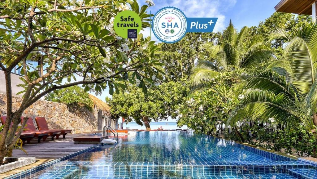 a swimming pool at a resort with palm trees at Sairee Hut Resort Koh Tao in Ko Tao