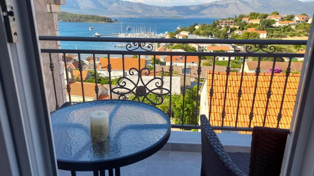 a table with a candle on a balcony with a view at Apartments Lumbarda in Lumbarda