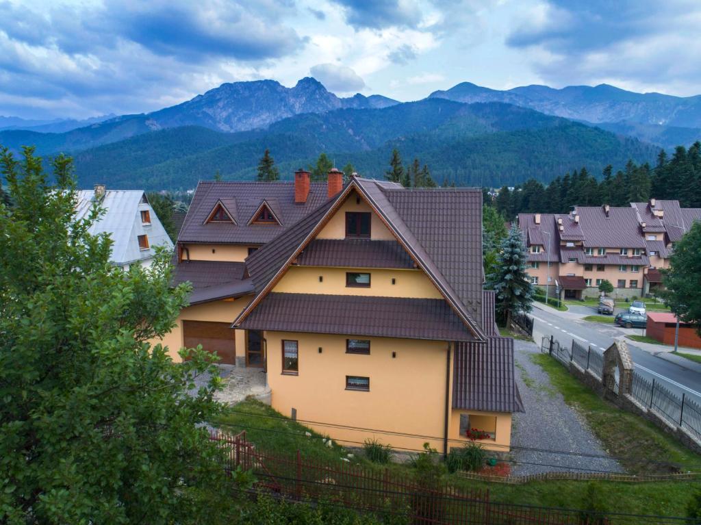 una casa con techo con montañas al fondo en VillaGiewont en Kościelisko