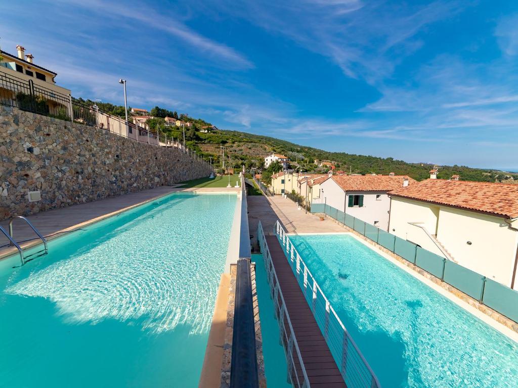 MaglioloにあるBorgo dei Fiori - relax and sea view with swimming poolの青い水と建物のあるスイミングプール