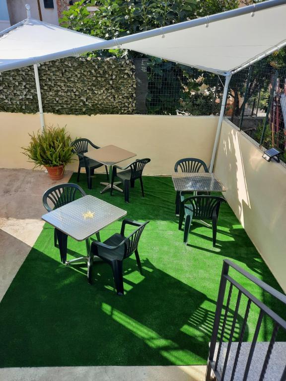 ポルト・サン・パーオロにあるAffittacamere D&Dの緑の芝生の上にテーブルと椅子が備わるパティオ