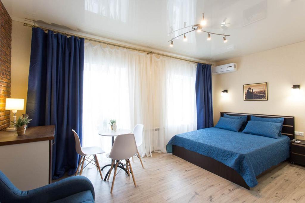 una camera con letto blu e tavolo e sedie di New apartments in the Centre - Kuznechna str. 26/3 a Charkiv