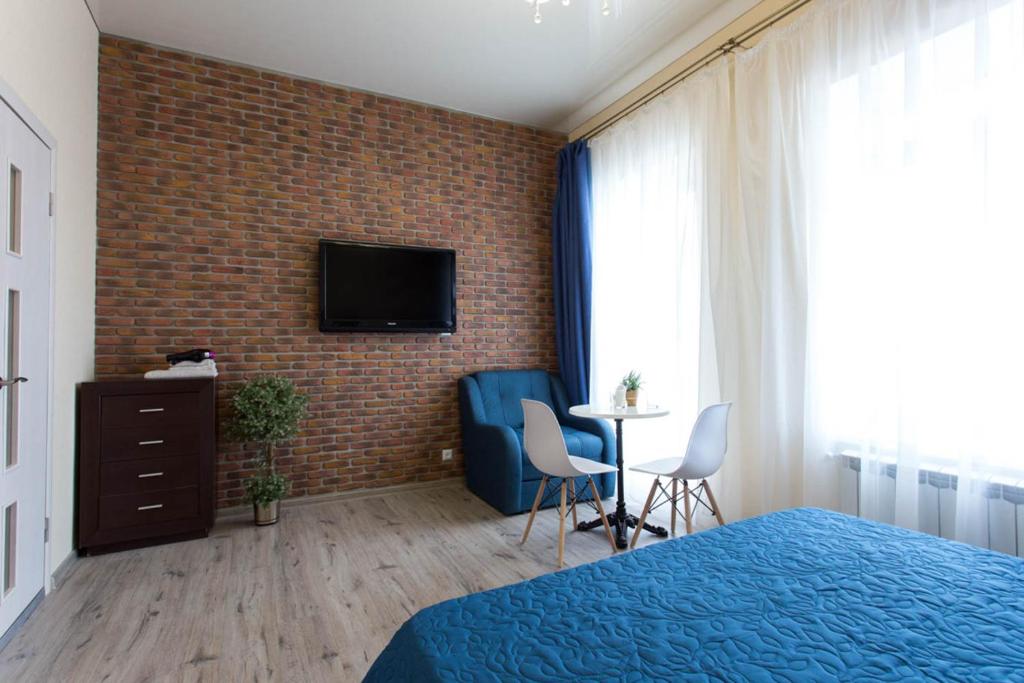 a bedroom with a bed and a tv on a brick wall at Modern apartments in the Centre - Kuznechna str. 26/4 in Kharkiv