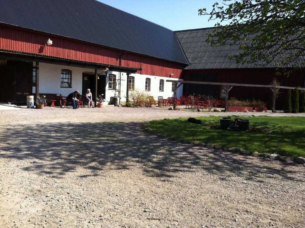 un grande fienile rosso e bianco con persone in piedi fuori di Hanksville Farm a Svalöv