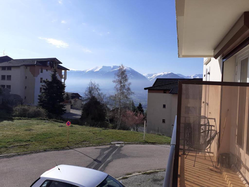 une voiture garée sur un balcon avec des montagnes en arrière-plan dans l'établissement Appartement T2 entièrement rénové dans résidence calme, à Font-Romeu-Odeillo-Via