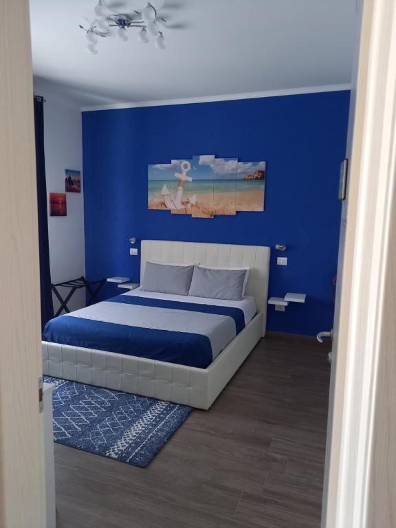 a blue bedroom with a bed with a blue wall at B&B villa brezza marina in Sant'Isidoro