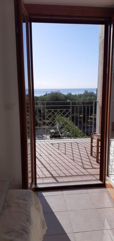 uma porta aberta para uma varanda com vista para o oceano em casa murata alta em San Vito Chietino