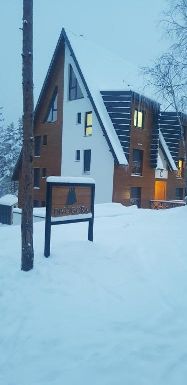 een bord in de sneeuw voor een gebouw bij Aprtman Divčigora C14 in Divčibare