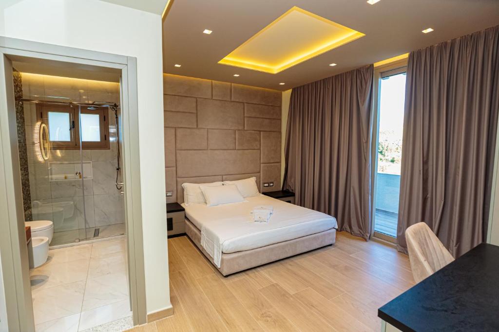 ein Hotelzimmer mit einem Bett und einer Dusche in der Unterkunft Vogue Boutique Hotel in Vlorë
