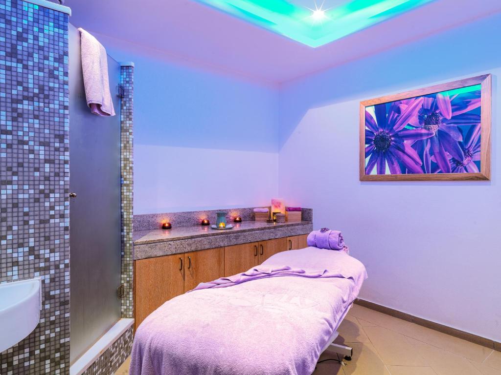 a bathroom with a purple bed and a sink at St Raphael Resort in Limassol
