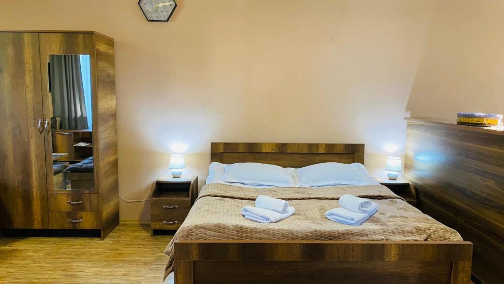 Lela Guest House في ميستيا: غرفة نوم عليها سرير وفوط بيضاء