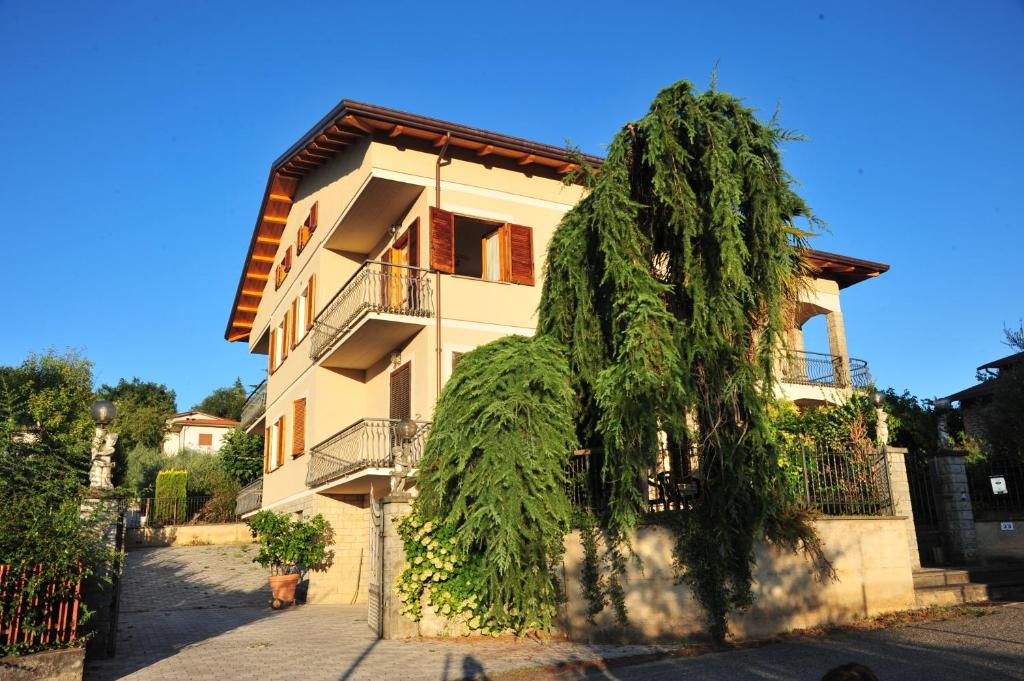 un edificio con un árbol delante de él en Il Mandorlo, en Sant'Orfeto