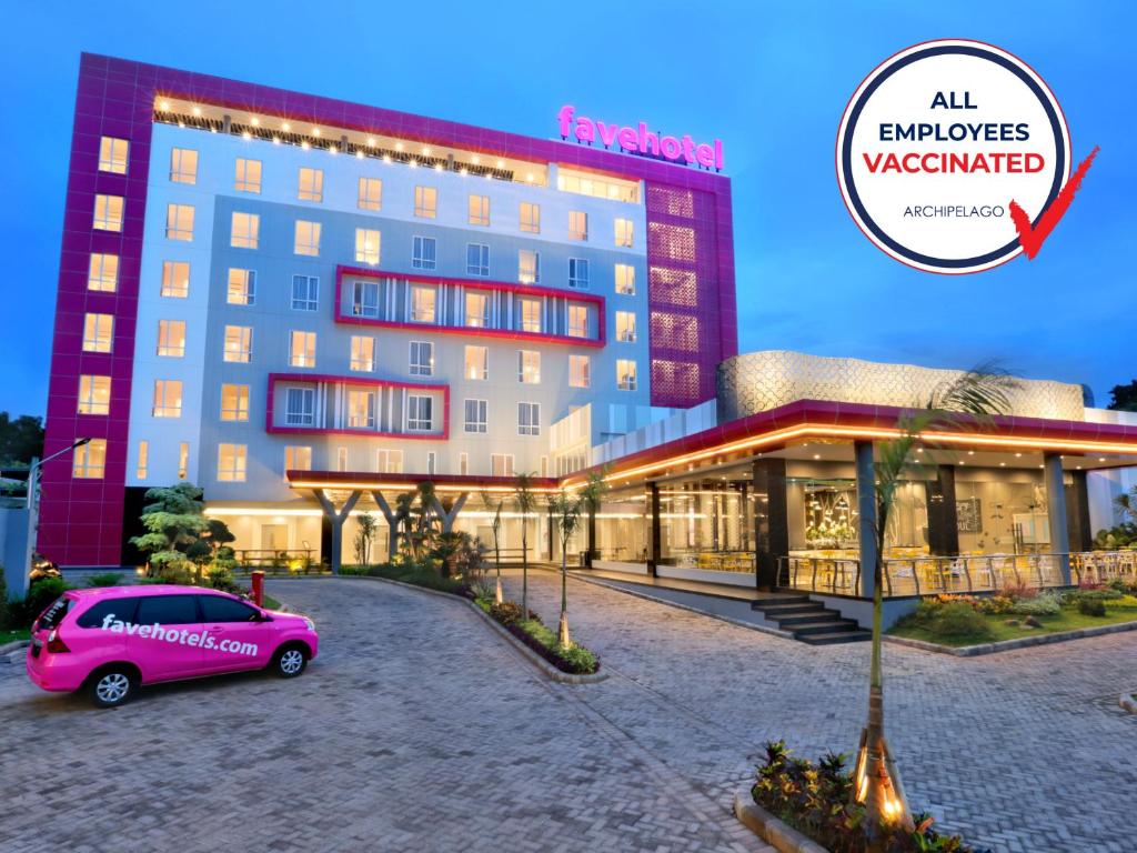 a pink car parked in front of a hotel at favehotel Tuban in Tuban