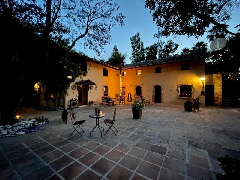 eine Terrasse mit Stühlen und einem Tisch vor einem Gebäude in der Unterkunft La Fuente Oase B&B in Coín