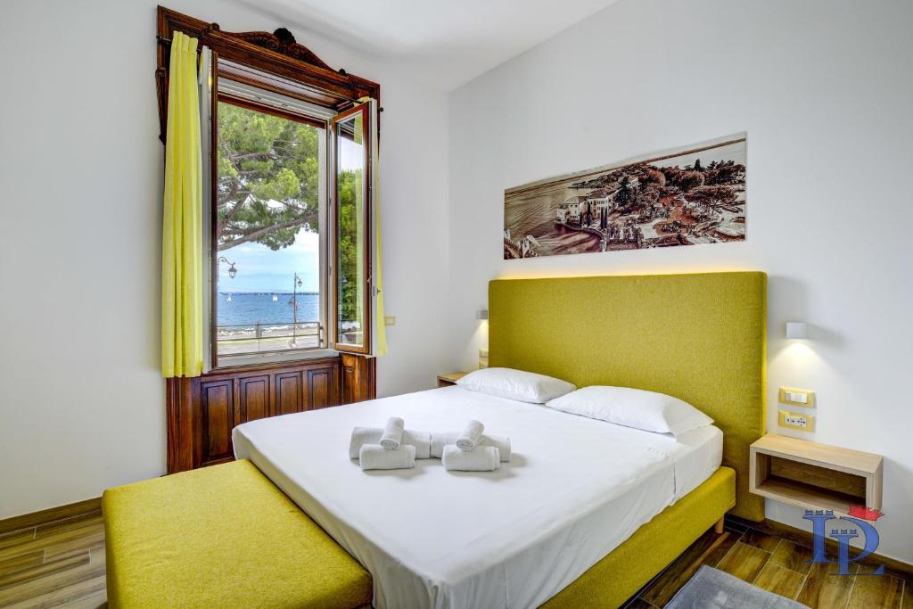 sypialnia z dużym łóżkiem i oknem w obiekcie DesenzanoLoft Palazzo Visconti Luxury Suite w mieście Desenzano del Garda