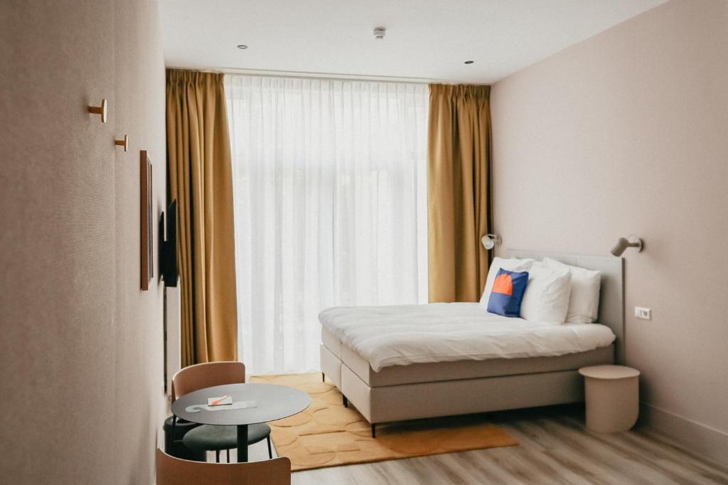 ein Hotelzimmer mit einem Bett und einem Tisch in der Unterkunft Hotel Bries Den Haag - Scheveningen in Den Haag