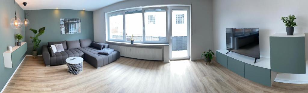 a living room with a couch and a tv at Moderne Ferienwohnung Hergolshausen in Waigolshausen