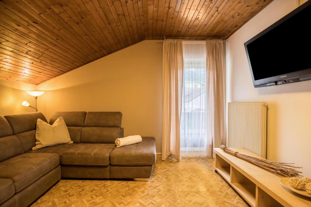 a living room with a couch and a flat screen tv at Apt Hofer Silena in Villabassa