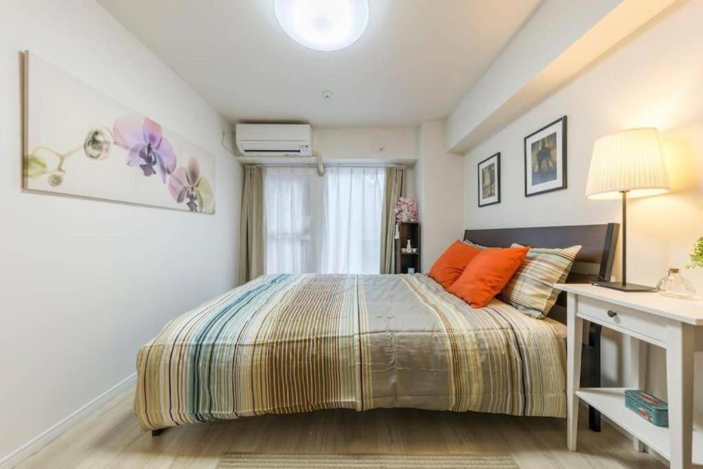 a bedroom with a bed and a window at HAMAMATSUCHO! 5 mins to subway sta with FREE-WIFI in Tokyo