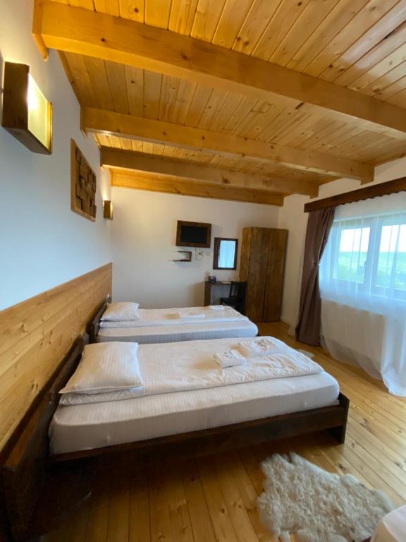 Dos camas en una habitación con techos de madera. en Retreat Margau Apuseni-Adults Only- wellness & wellbeing, en Mărgău
