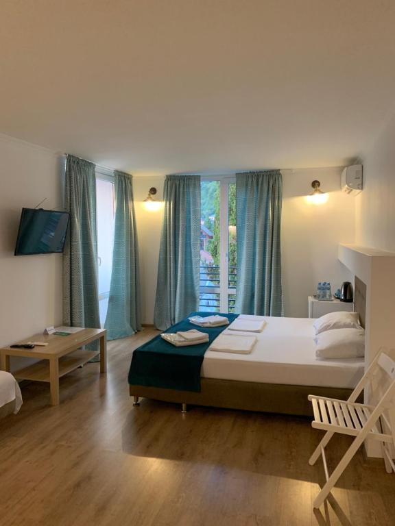 Un dormitorio con una cama grande y una ventana en Мини-отель New Gagra, en Gagra