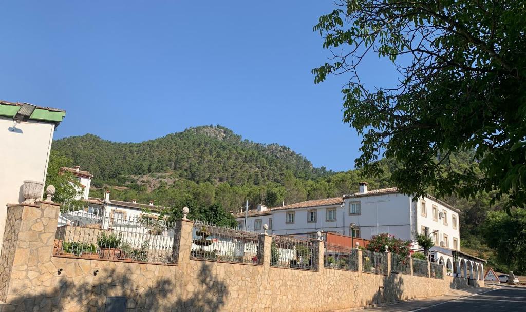 a stone wall with houses and a mountain in the background at Hotel Mirasierra in Coto Rios