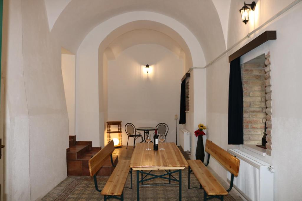 une salle à manger avec une table et des bancs en bois dans l'établissement Bezauberndes Gästehaus in Satov, à Šatov
