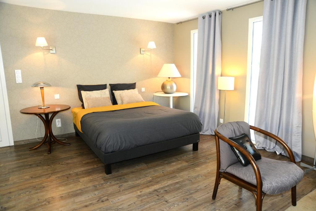 una camera con letto, sedia e tavolo di La Maison des Hérissons a Bergerac